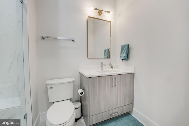 bathroom with baseboards, toilet, and vanity