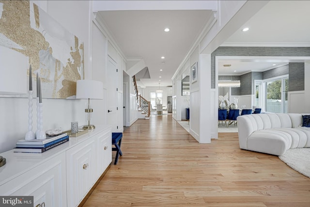 entryway featuring recessed lighting, light wood-type flooring, ornamental molding, and stairway