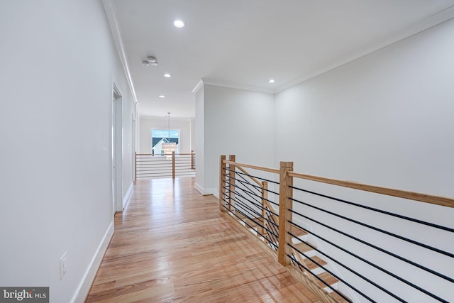 hall with baseboards, light wood finished floors, recessed lighting, ornamental molding, and an upstairs landing