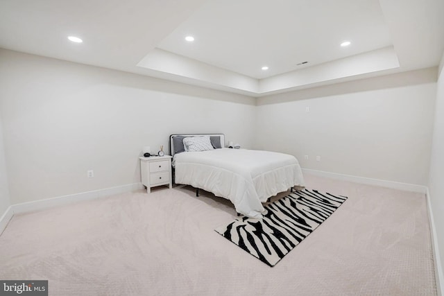 bedroom featuring a tray ceiling, recessed lighting, baseboards, and carpet floors