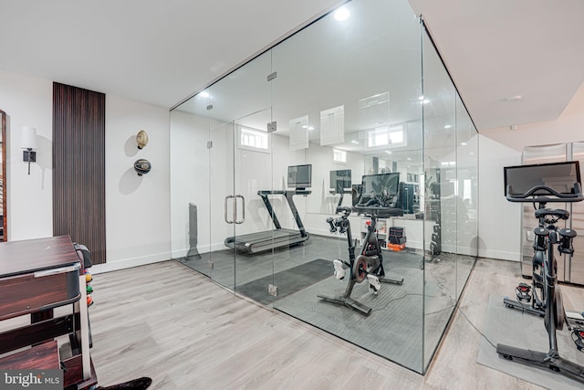 exercise area with wood finished floors and baseboards