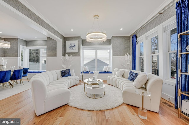 living area featuring wood finished floors, crown molding, and wallpapered walls