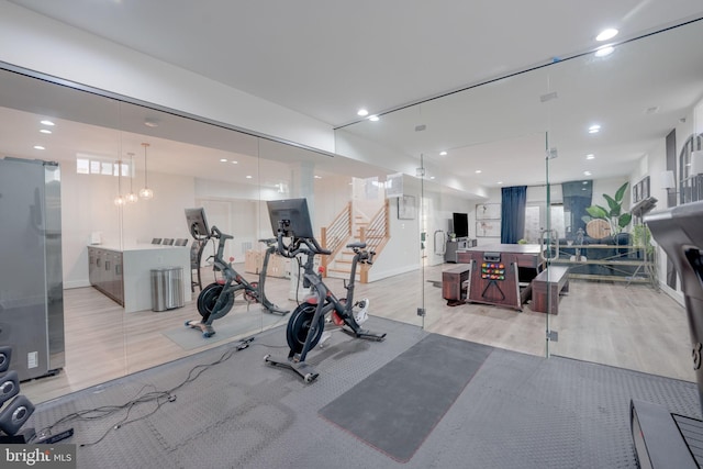 exercise area with wood finished floors, recessed lighting, and baseboards