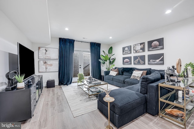 living area with recessed lighting, light wood-style floors, baseboards, and french doors