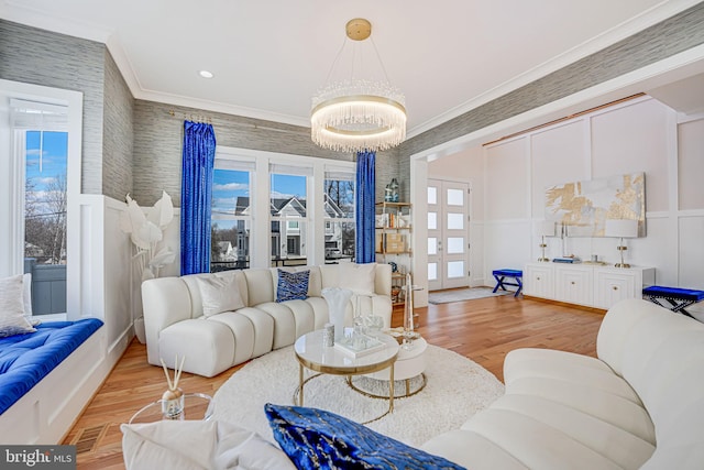 living area with wood finished floors, crown molding, and a decorative wall