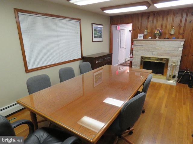 office with light wood-type flooring and a stone fireplace