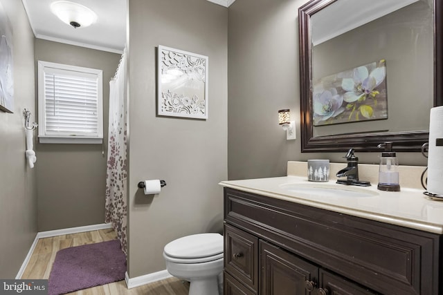 bathroom with vanity, wood finished floors, toilet, and baseboards