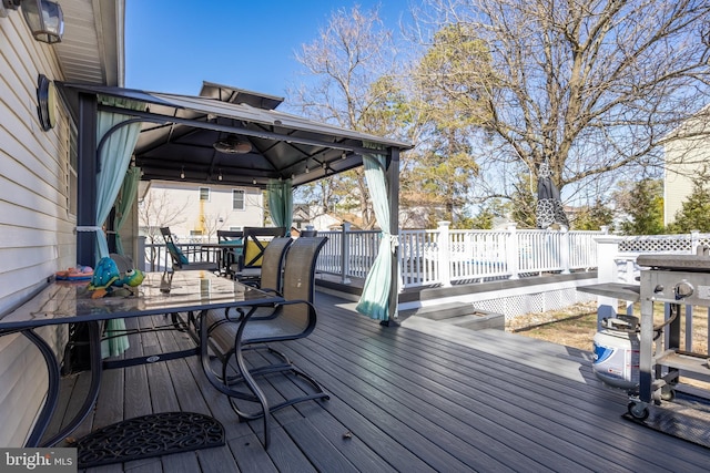 wooden terrace with a gazebo and outdoor dining area