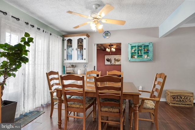 dining space with ceiling fan, a textured ceiling, and wood finished floors