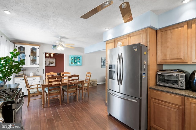 kitchen featuring a toaster, dark wood-style floors, ceiling fan, appliances with stainless steel finishes, and glass insert cabinets