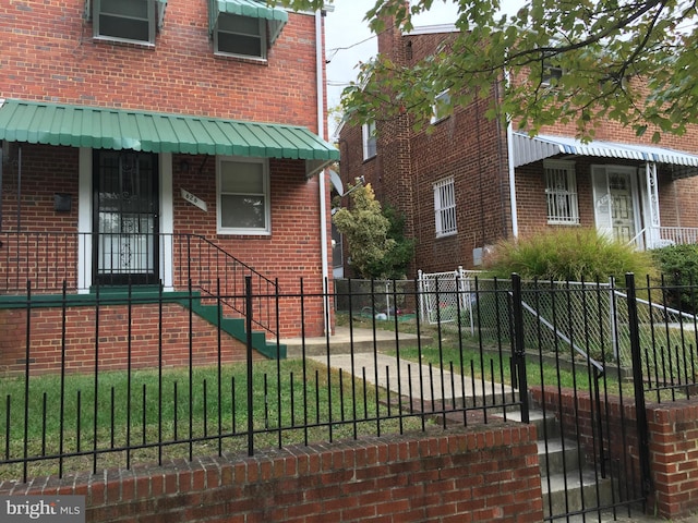 view of home's exterior with a fenced front yard and brick siding