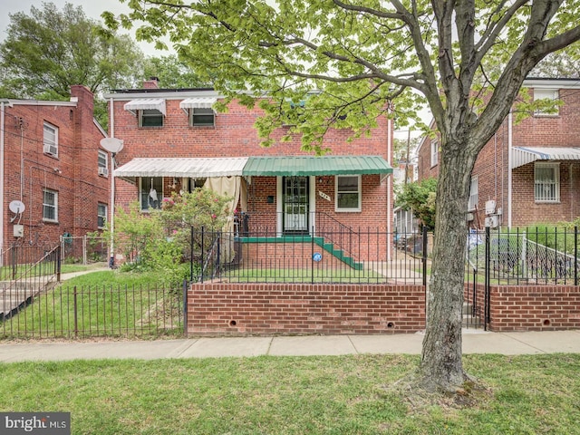 view of front of property featuring brick siding, a front lawn, and a fenced front yard