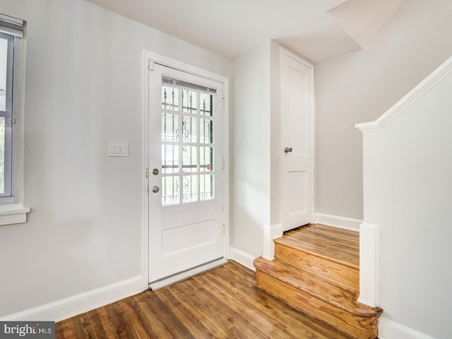 foyer with baseboards and wood finished floors