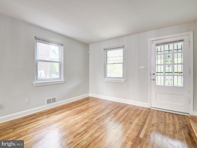 interior space with visible vents, baseboards, and hardwood / wood-style floors