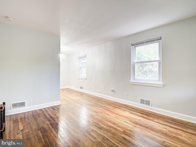 spare room with visible vents, wood-type flooring, and baseboards