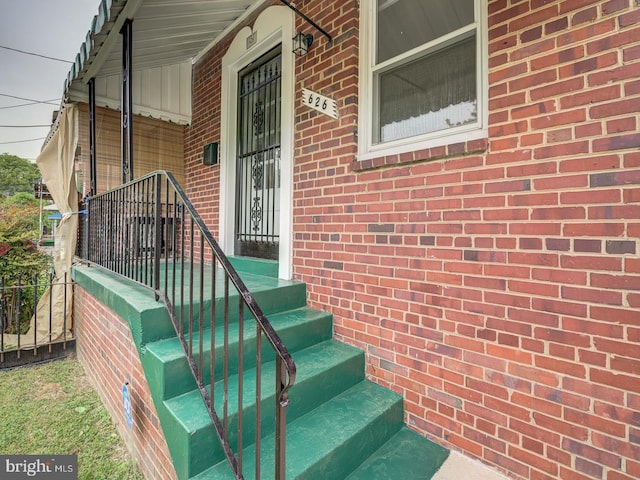 property entrance featuring brick siding