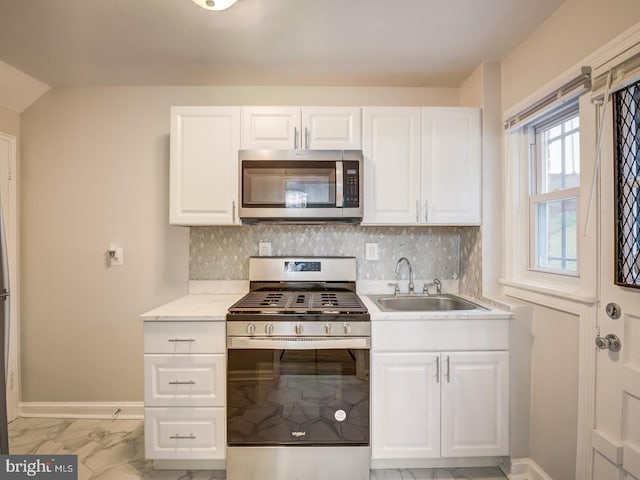 kitchen featuring a sink, decorative backsplash, marble finish floor, and appliances with stainless steel finishes