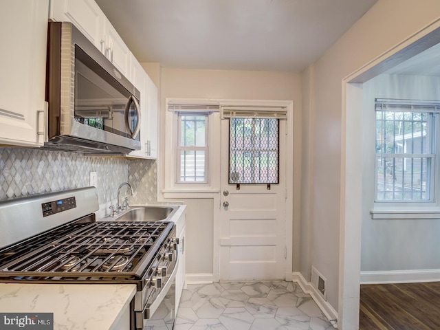 kitchen featuring a healthy amount of sunlight, visible vents, appliances with stainless steel finishes, and a sink