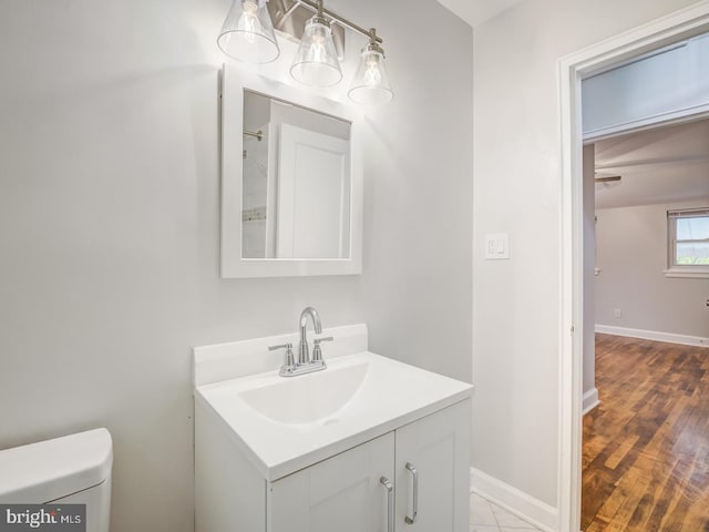 bathroom with vanity, toilet, and baseboards