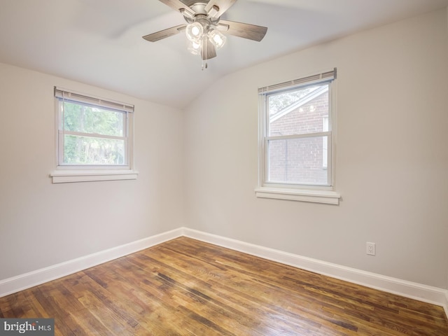 empty room with ceiling fan, lofted ceiling, baseboards, and wood finished floors