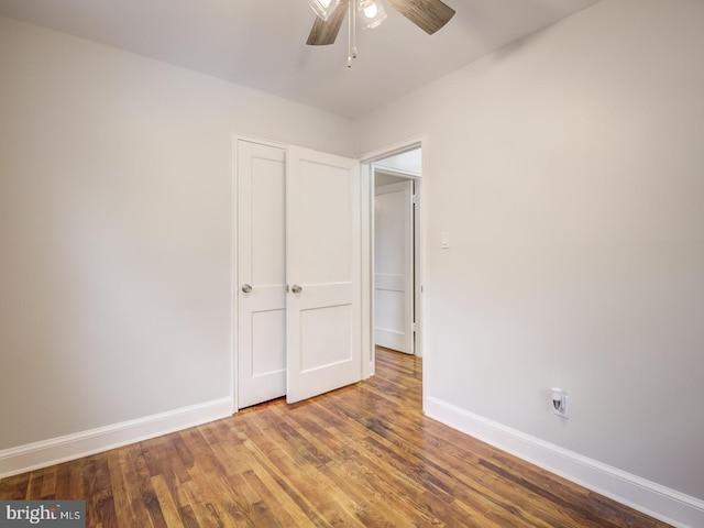 unfurnished bedroom with wood finished floors, baseboards, and ceiling fan