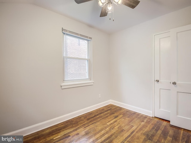 spare room with a ceiling fan, wood finished floors, and baseboards