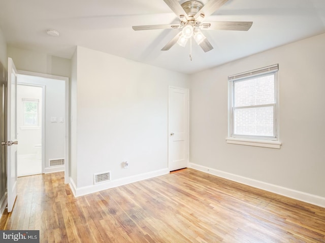 unfurnished room with ceiling fan, visible vents, baseboards, and light wood-style flooring