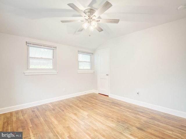 unfurnished room with lofted ceiling, baseboards, light wood finished floors, and ceiling fan