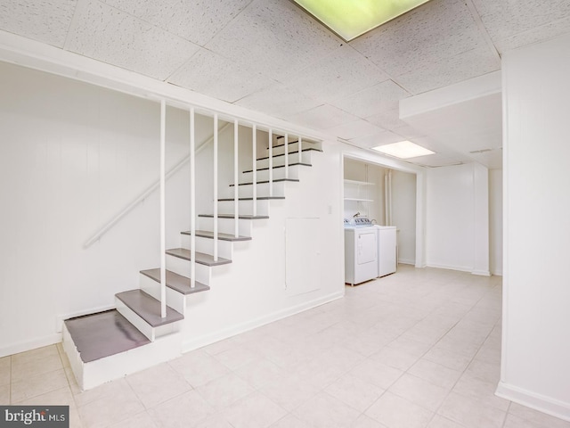 stairs with a paneled ceiling, independent washer and dryer, and baseboards