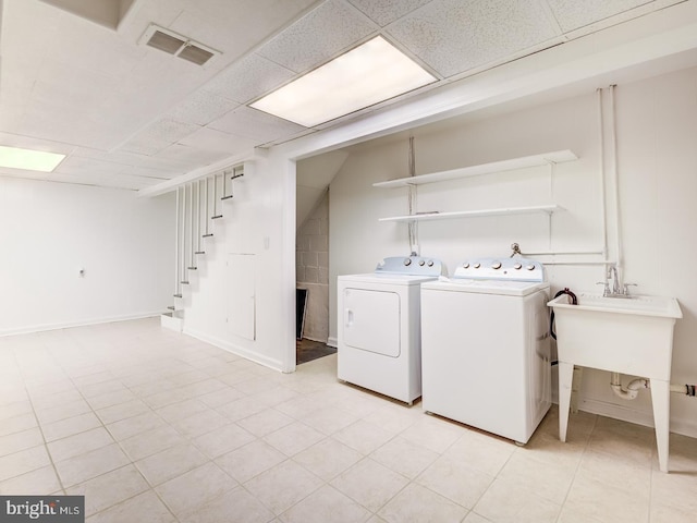 washroom featuring washer and dryer, visible vents, baseboards, and a sink