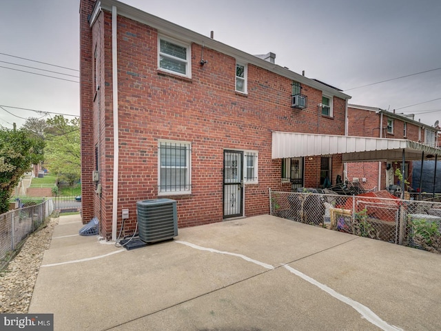 back of property featuring brick siding, a patio area, and cooling unit