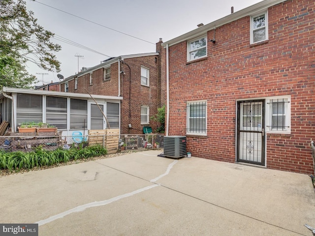 back of house with central air condition unit, brick siding, and fence