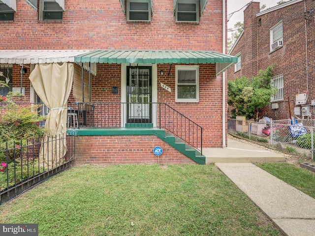 entrance to property with brick siding and fence