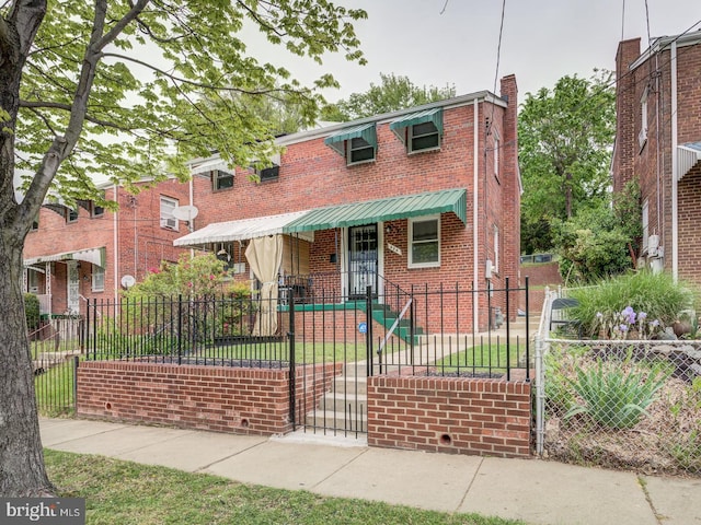 view of front facade with brick siding and a fenced front yard