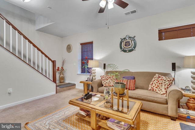 living area with visible vents, stairway, light carpet, ceiling fan, and baseboards