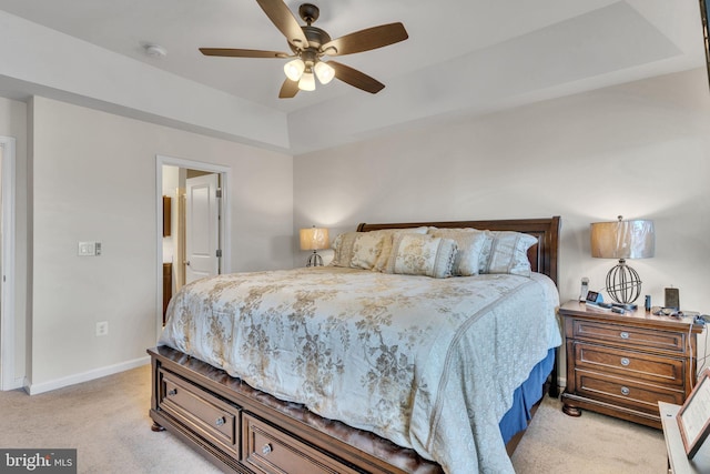 bedroom with baseboards, ceiling fan, a tray ceiling, and light colored carpet