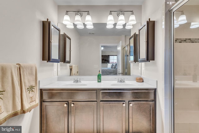 ensuite bathroom with double vanity, a stall shower, a sink, and connected bathroom