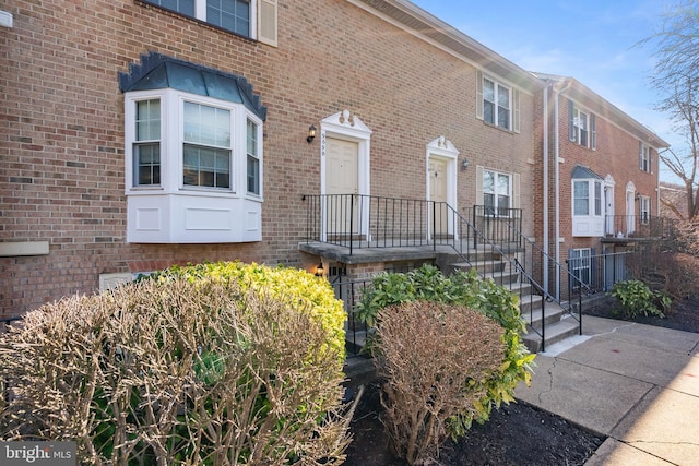 doorway to property featuring brick siding