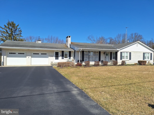 single story home featuring brick siding, a front lawn, aphalt driveway, a chimney, and an attached garage