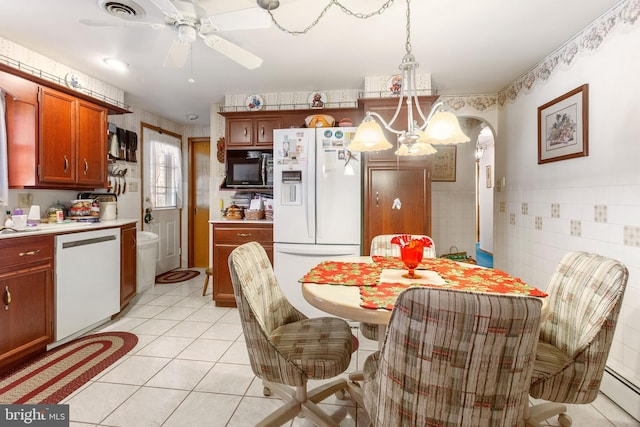 dining space with visible vents, a wainscoted wall, tile walls, light tile patterned floors, and a baseboard radiator