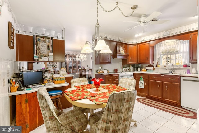 kitchen featuring light tile patterned floors, white dishwasher, light countertops, custom range hood, and ceiling fan with notable chandelier