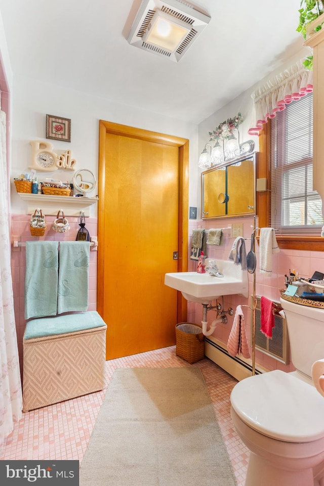 bathroom featuring tile patterned flooring, toilet, visible vents, and a baseboard heating unit