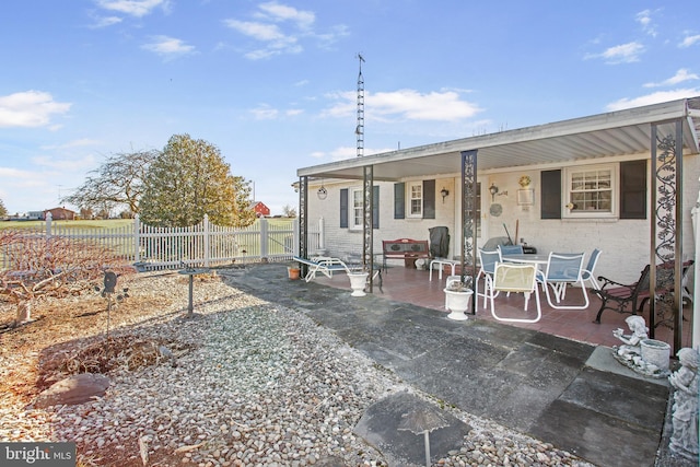 back of property with a patio area, brick siding, and fence