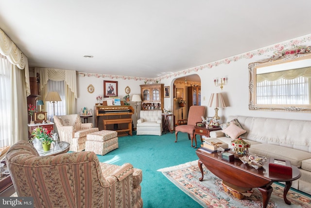 carpeted living room featuring arched walkways