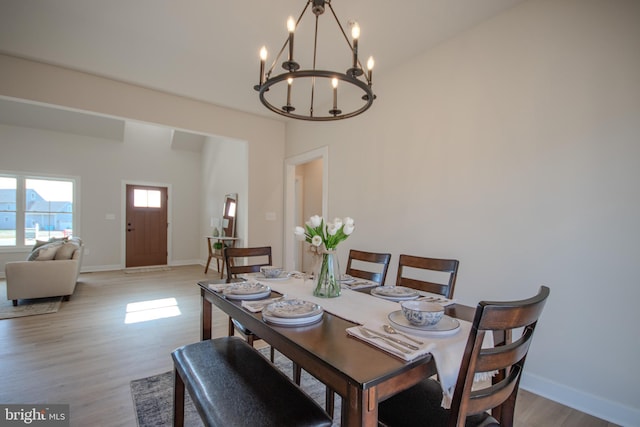 dining area with a notable chandelier, wood finished floors, and baseboards