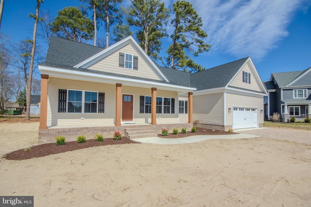 view of front of home with a porch, a shingled roof, a garage, and dirt driveway