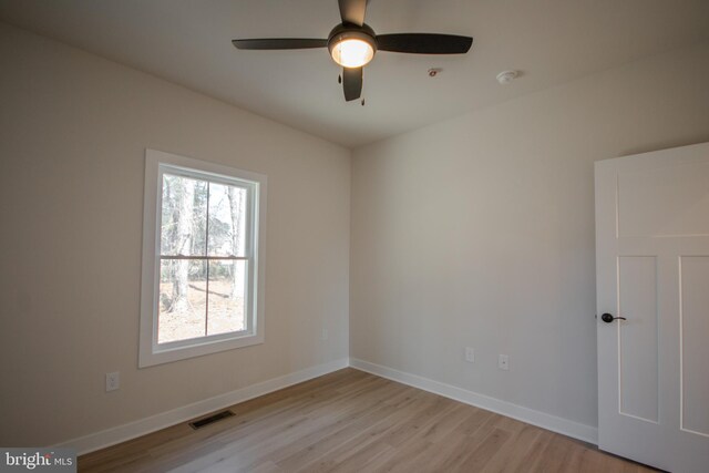 unfurnished room featuring visible vents, a ceiling fan, light wood-type flooring, and baseboards