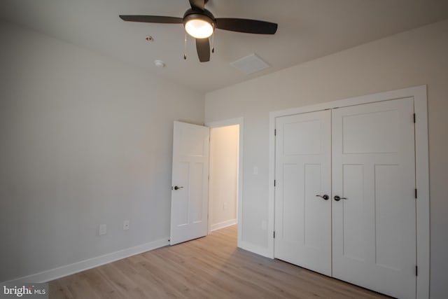 unfurnished bedroom with a closet, baseboards, a ceiling fan, and light wood finished floors