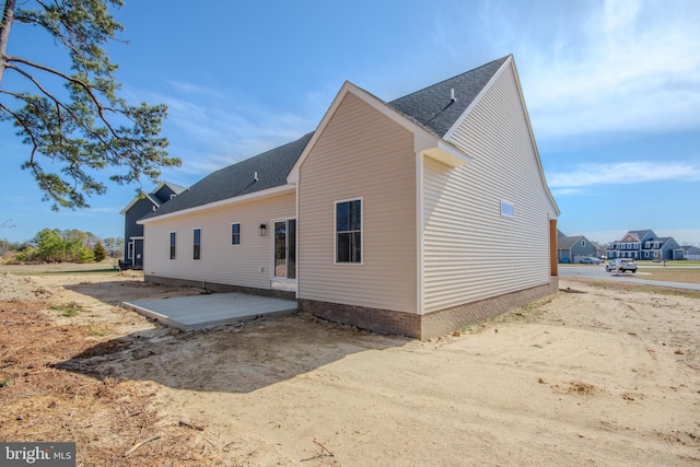 back of house with a patio area and roof with shingles