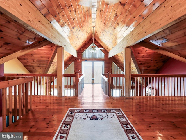 hallway featuring lofted ceiling with beams, wooden walls, wooden ceiling, and wood-type flooring